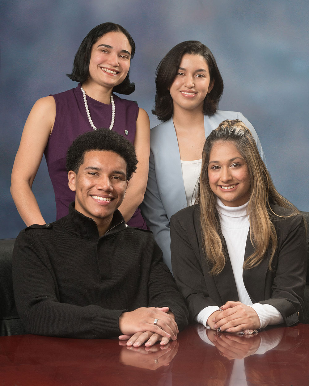 Portrait photo of student trustees Adriana Dos Santo and Ixchel Valencia Diaz standing in back and Diego Bethea and Saigel Ghotra in front