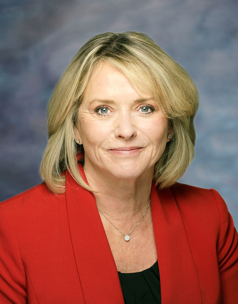 Portrait photo of Kelly Hall wearing a red jacket