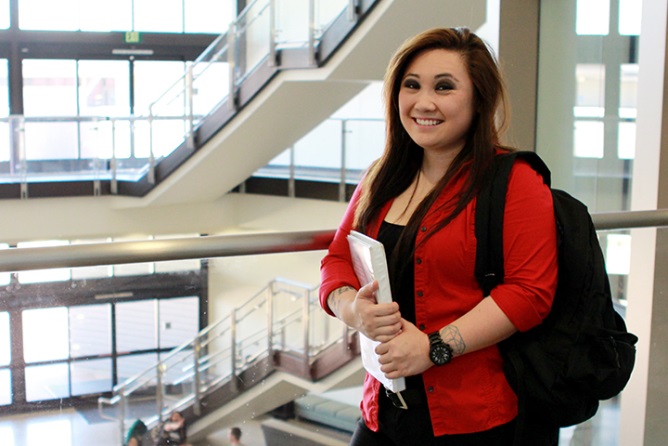 Thaimae Le holds books in a hallway at Miramar College