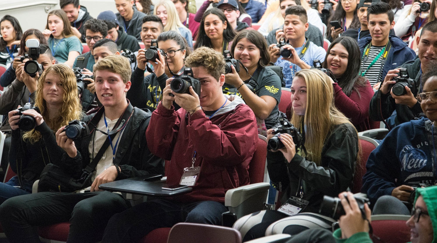 Students hold up their cameras to take a picture.