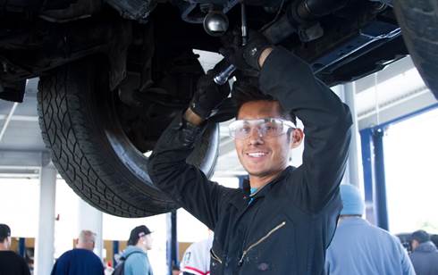 An Auto program student puts a tire on a car