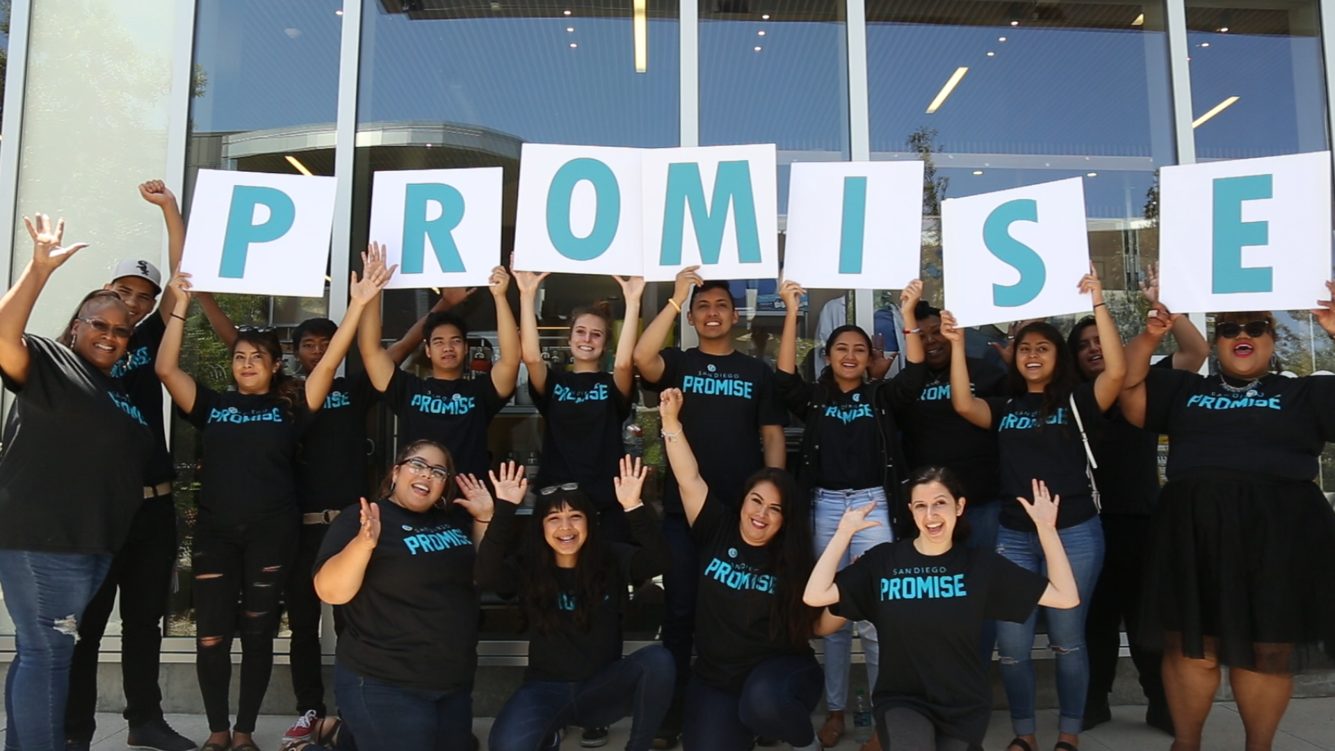Promise students in a group holding up letters spelling promise