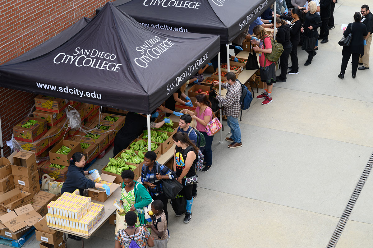 Volunteers hand out food during City College's farmers market