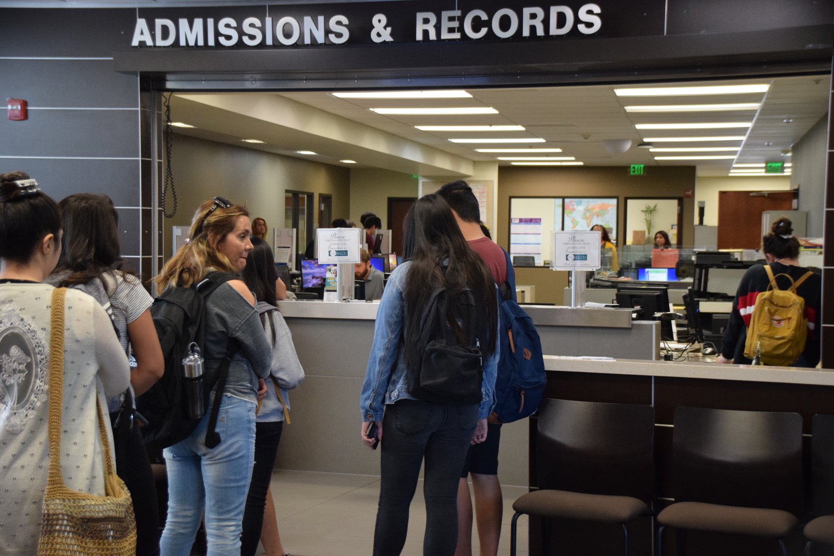 3 students in line for the admissions desk