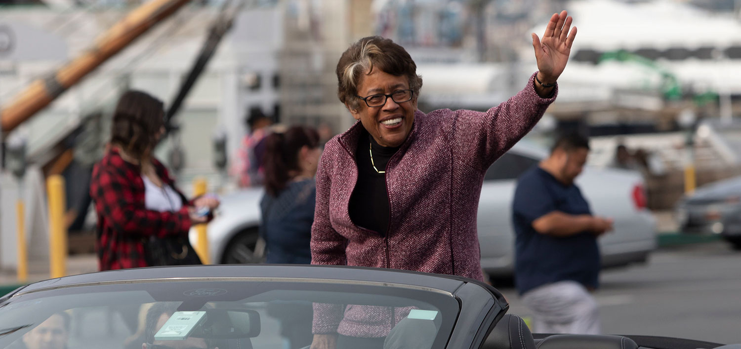 Constance Carroll waves from a car at a parade
