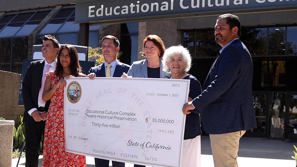 District and community leaders hold a large check for $35 million