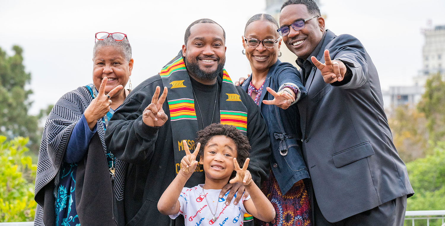 George Buchanan and his son with three Mesa officials at commencement
