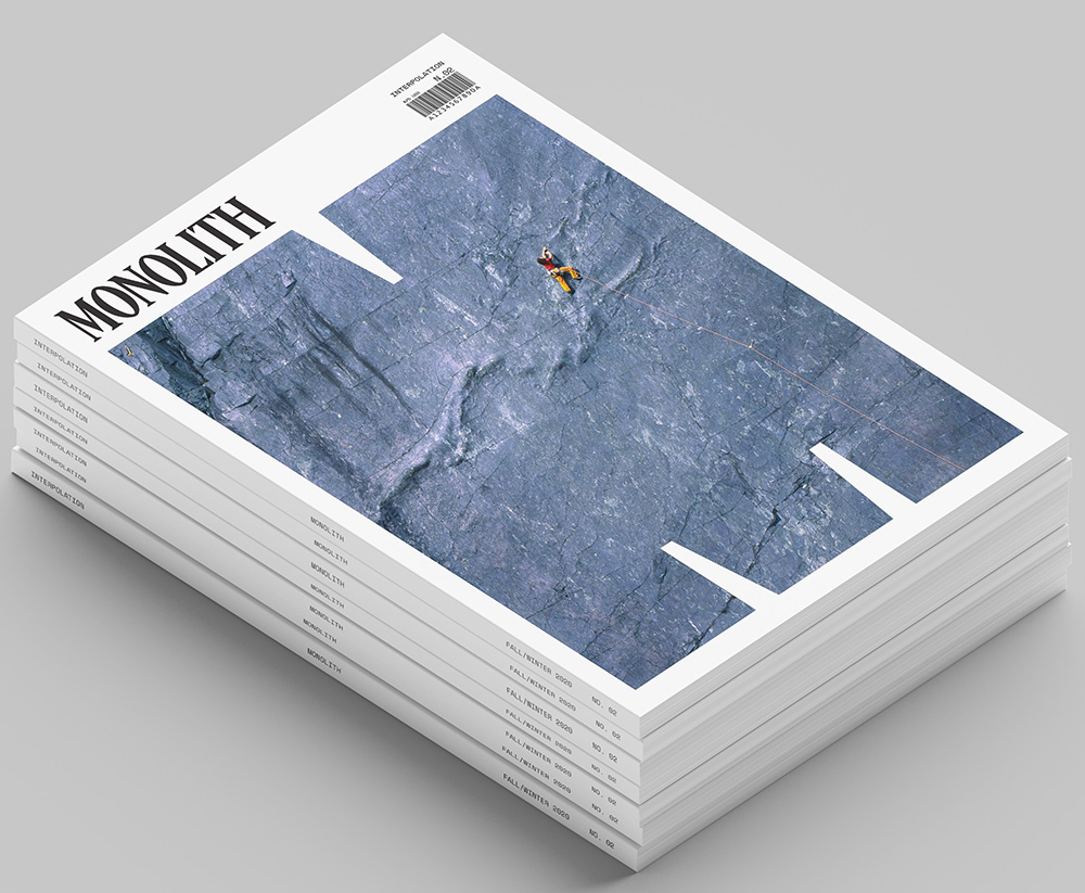 A stack of Monolith magazines. The cover of the top magazine shows an image of a person climbing a monolith