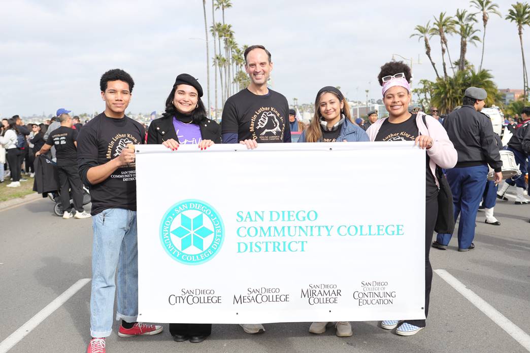 Greg Smith and four students hold up the district banner at the MLK parade.