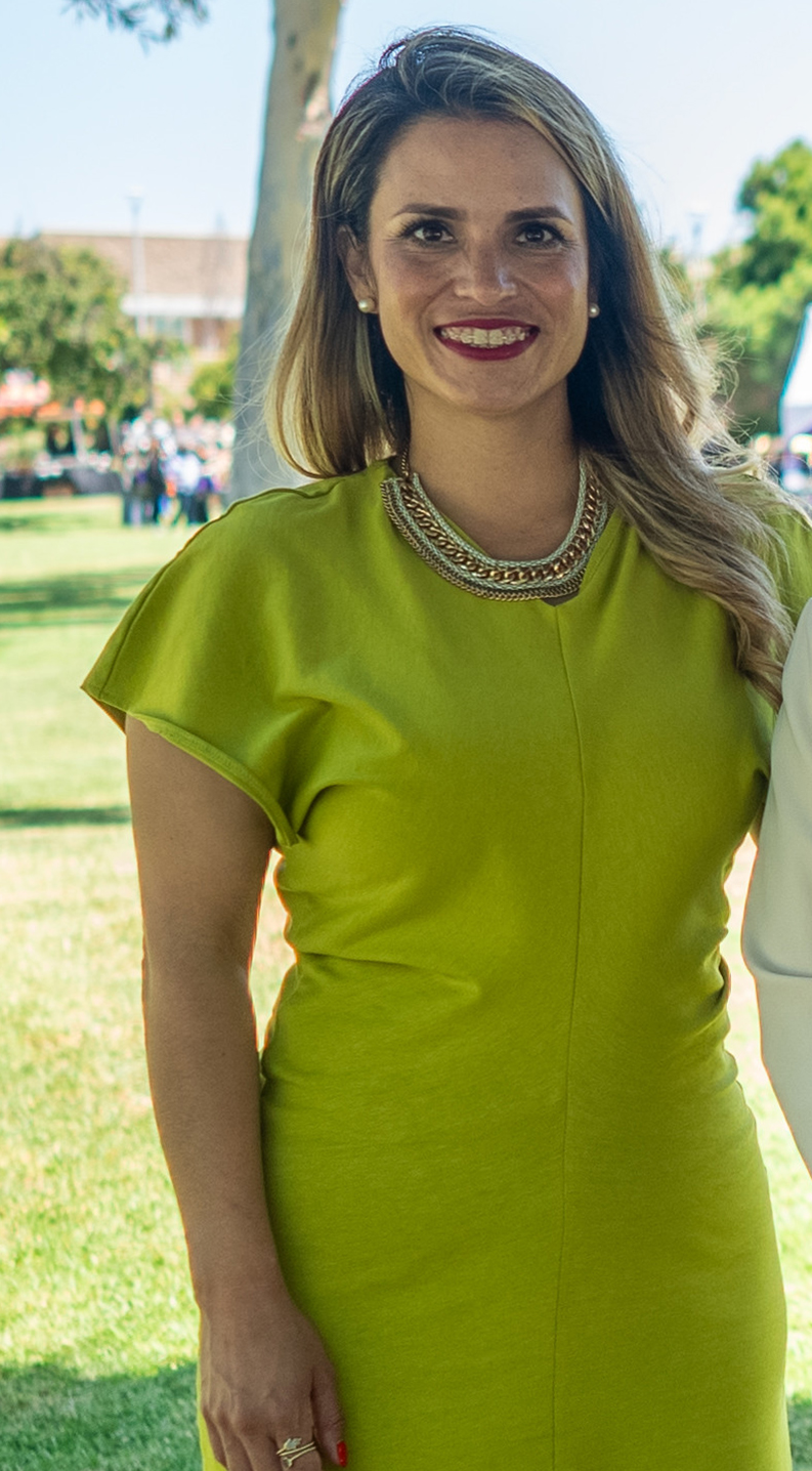 Haydee Zuniga outside with a tree behind her. She is wearing a lime green dress
