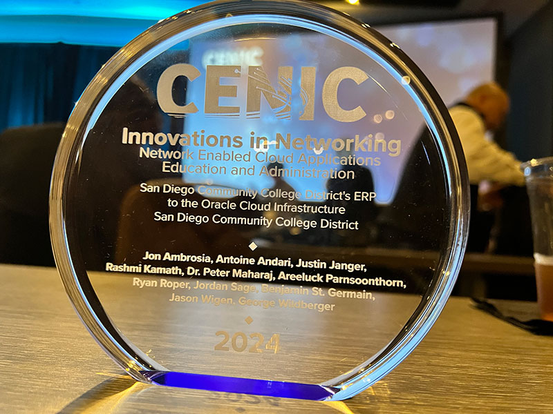 A close up of the award. It is round and glass with several names carved into it.