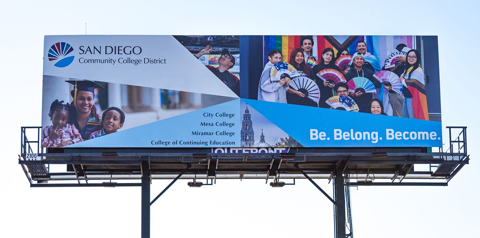 A billboard with pictures of students the district logo and tagline Be Belong Become