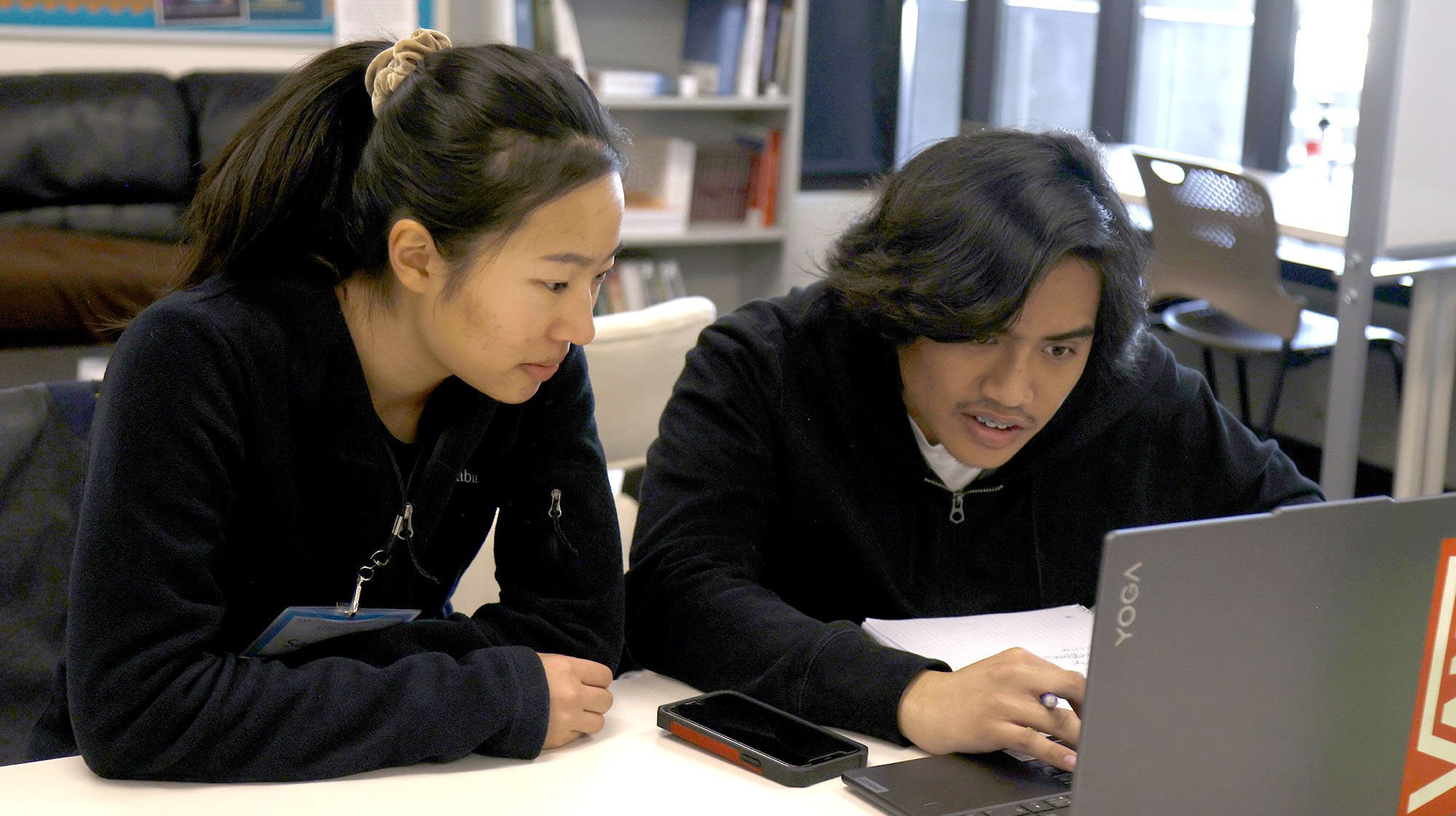 Two people in the tutoring center work on a laptop