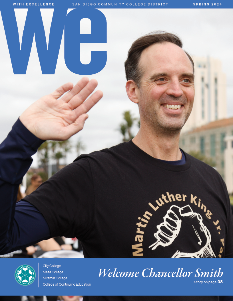 Gregory Smith in a black tee shirt is waving to the crowd at the MLK parade