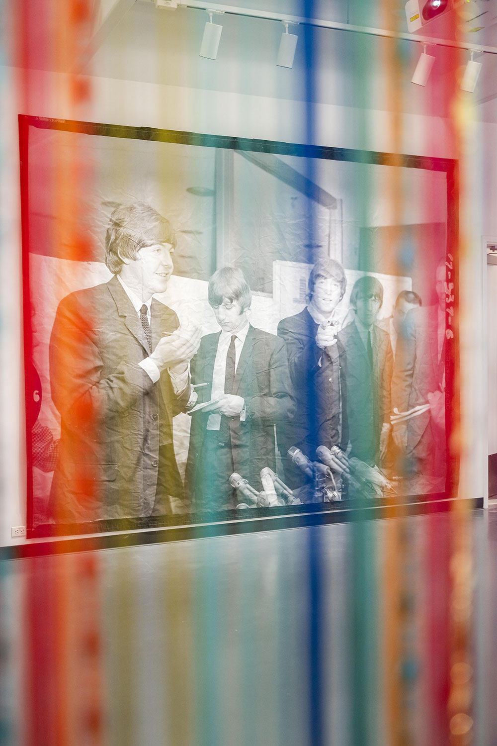A sheer rainbow cloth in front of a black and white Beatles photo
