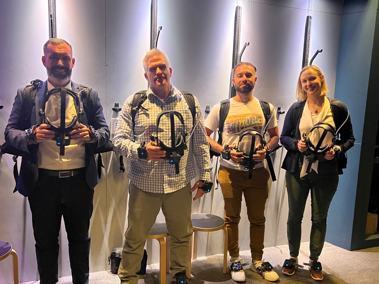Four people holding virtual reality goggles.
