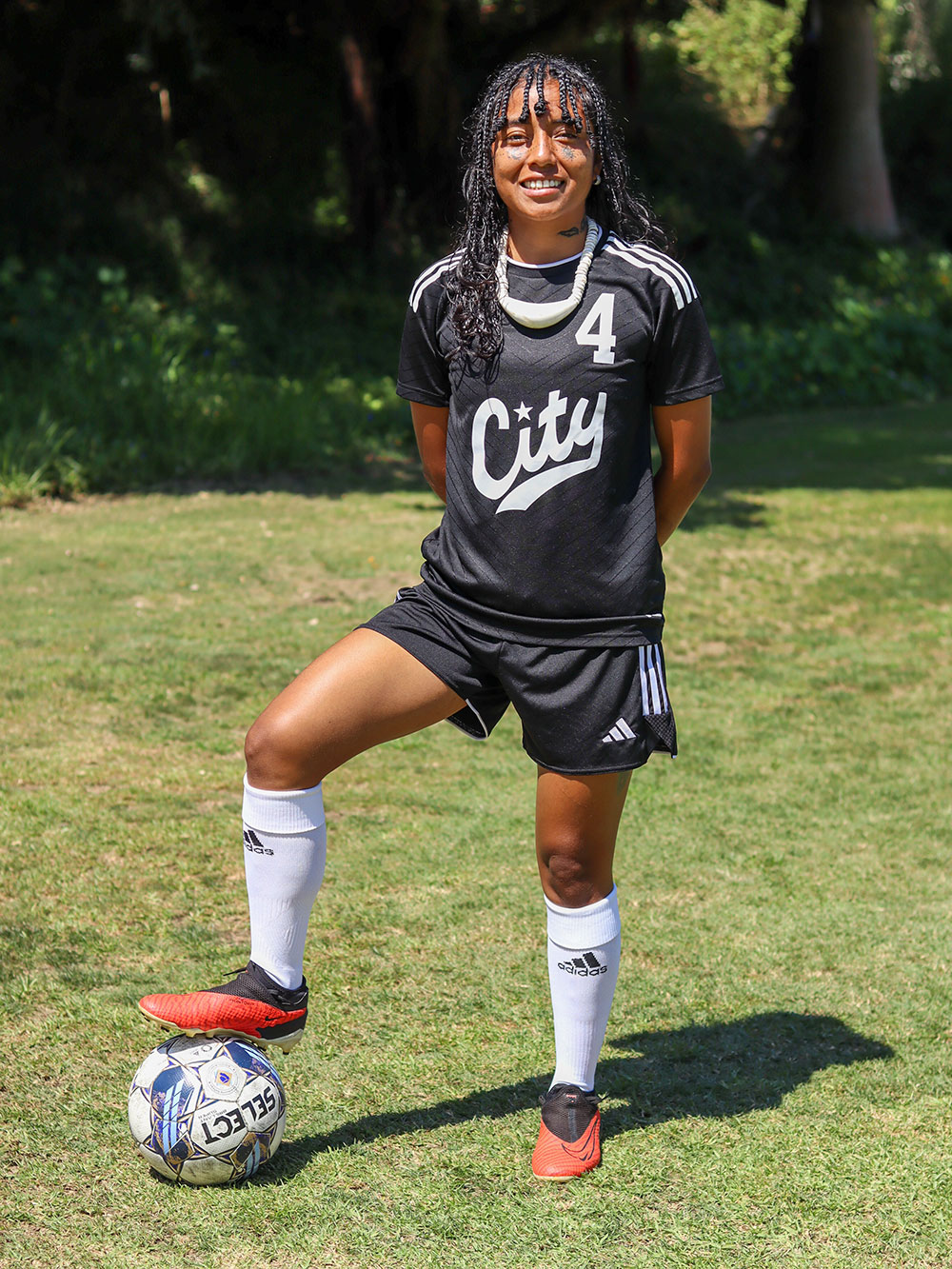 Karin Angel on the field in a black and white soccer uniform with a soccer ball