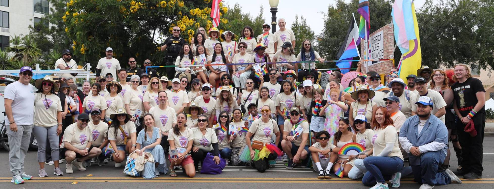 About 100 students and staff take a group photo at the pride parade in 2025.