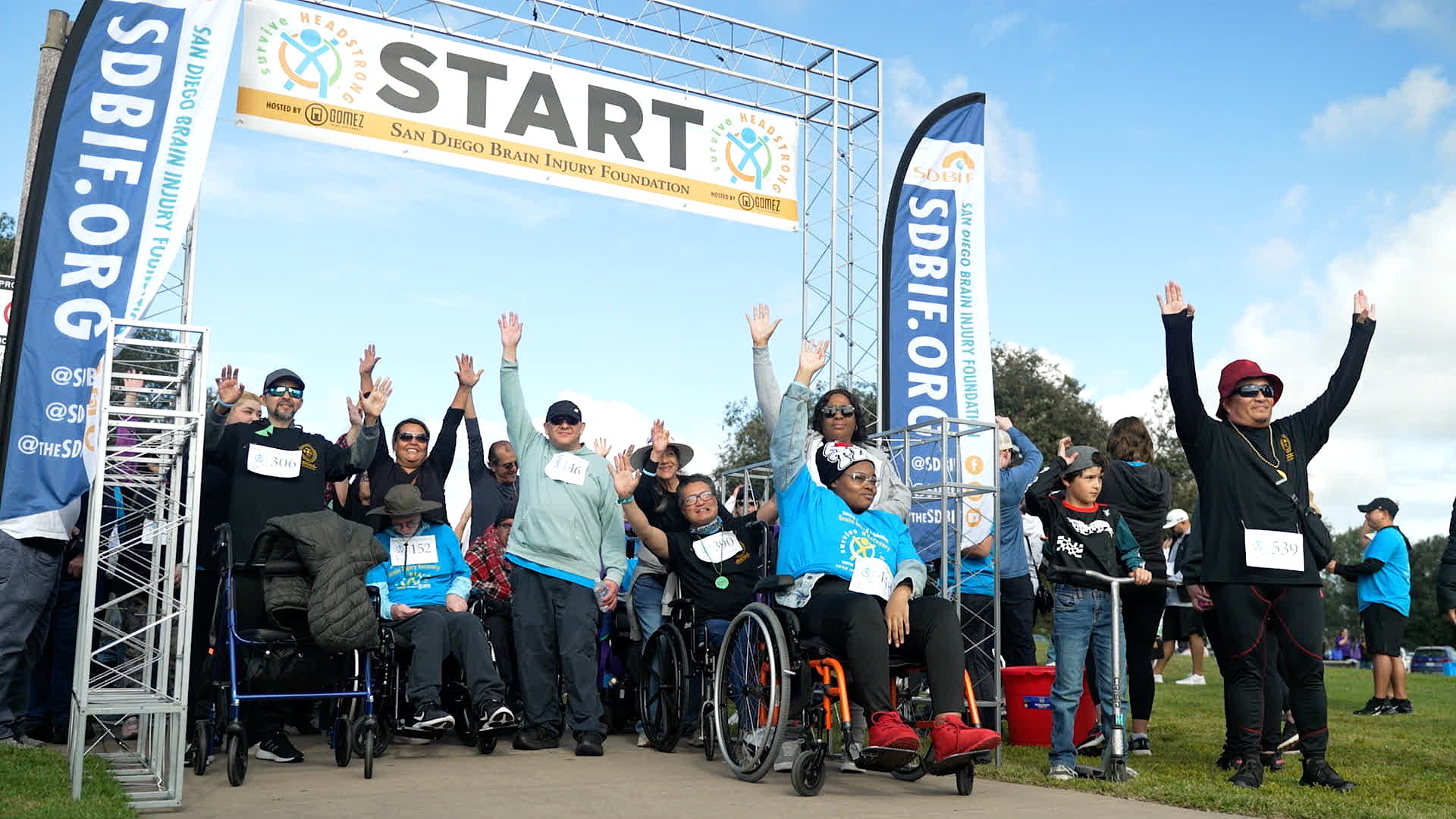A large group under a banner at the start of the fundraiser walk