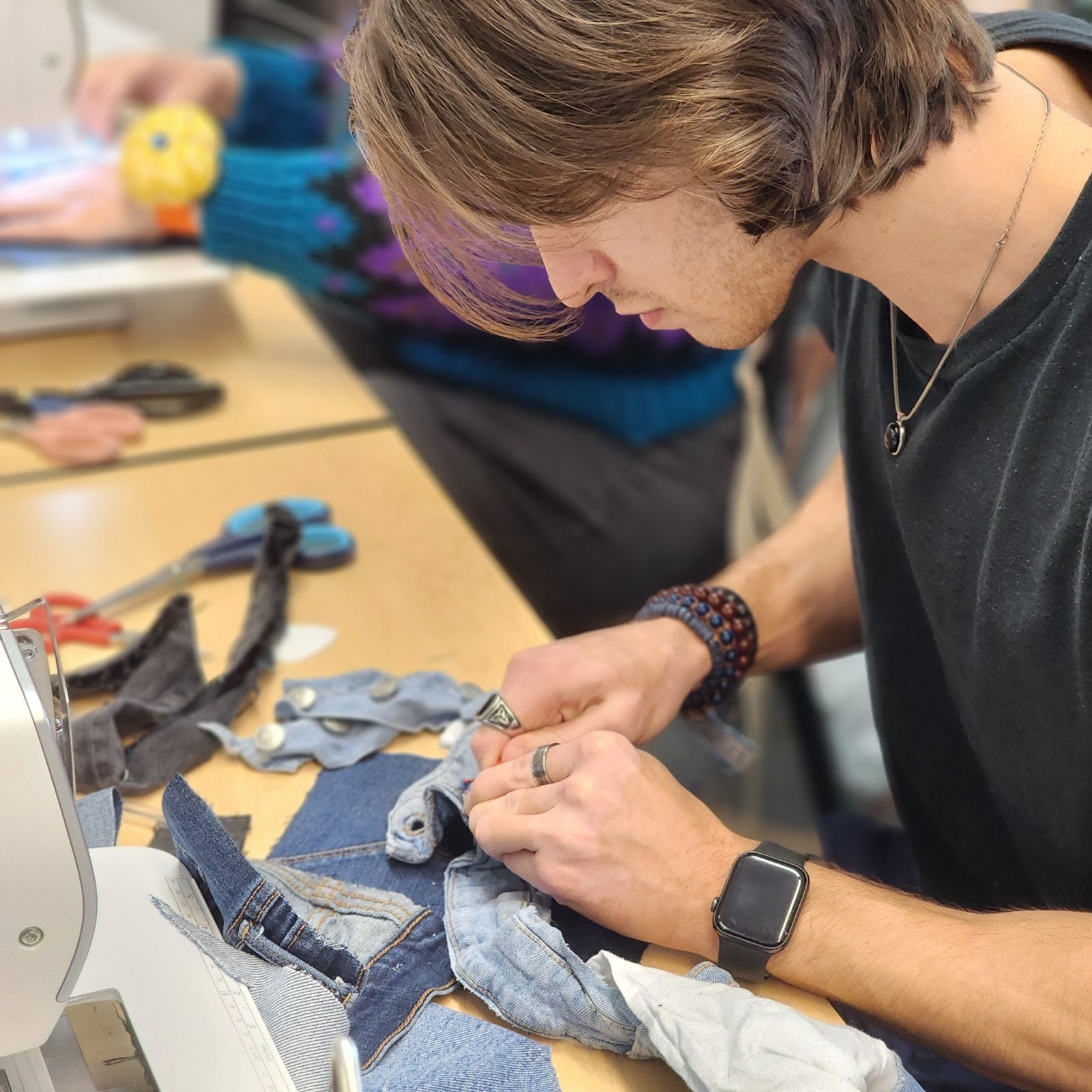 A student sewing at a workstation
