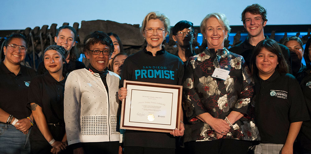 Acress Annette Bening with Chancellor Emerita Constance Carroll on stage with 20 people at a Promise Fundraiser