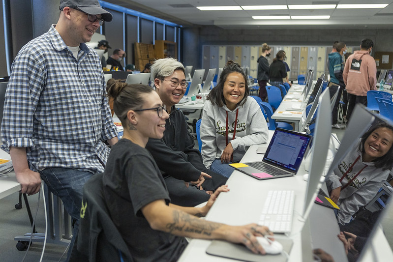Students at a City College graphic design class looking at a computer