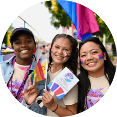 Three students holding SDCCD materials and pride flags
