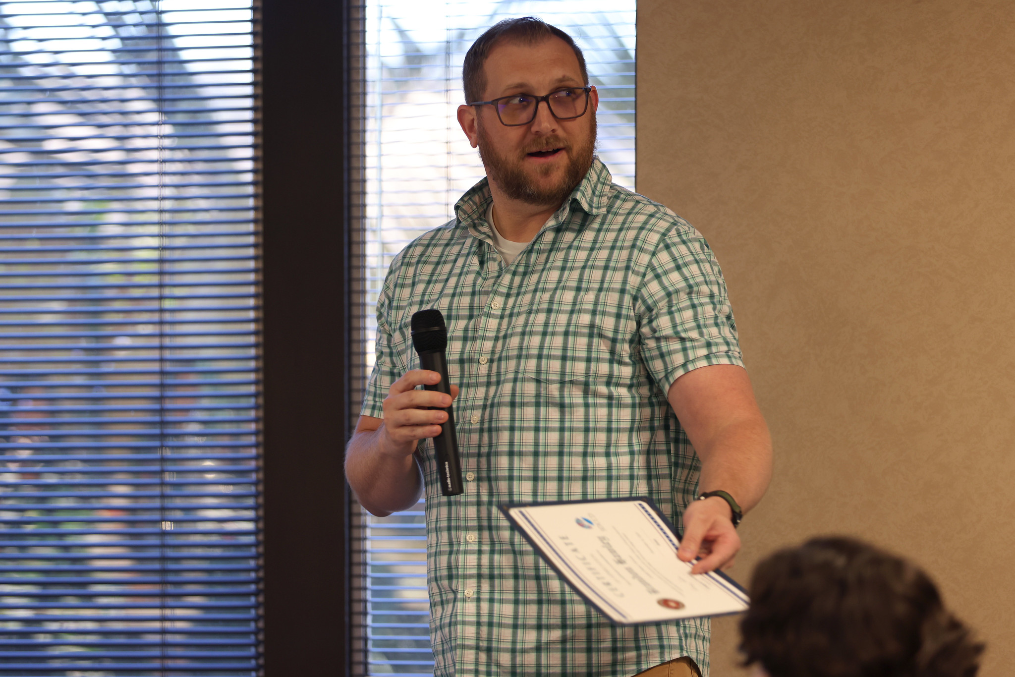 Veteran Brandon Hawley holds the microphone at the Veterans Day event.