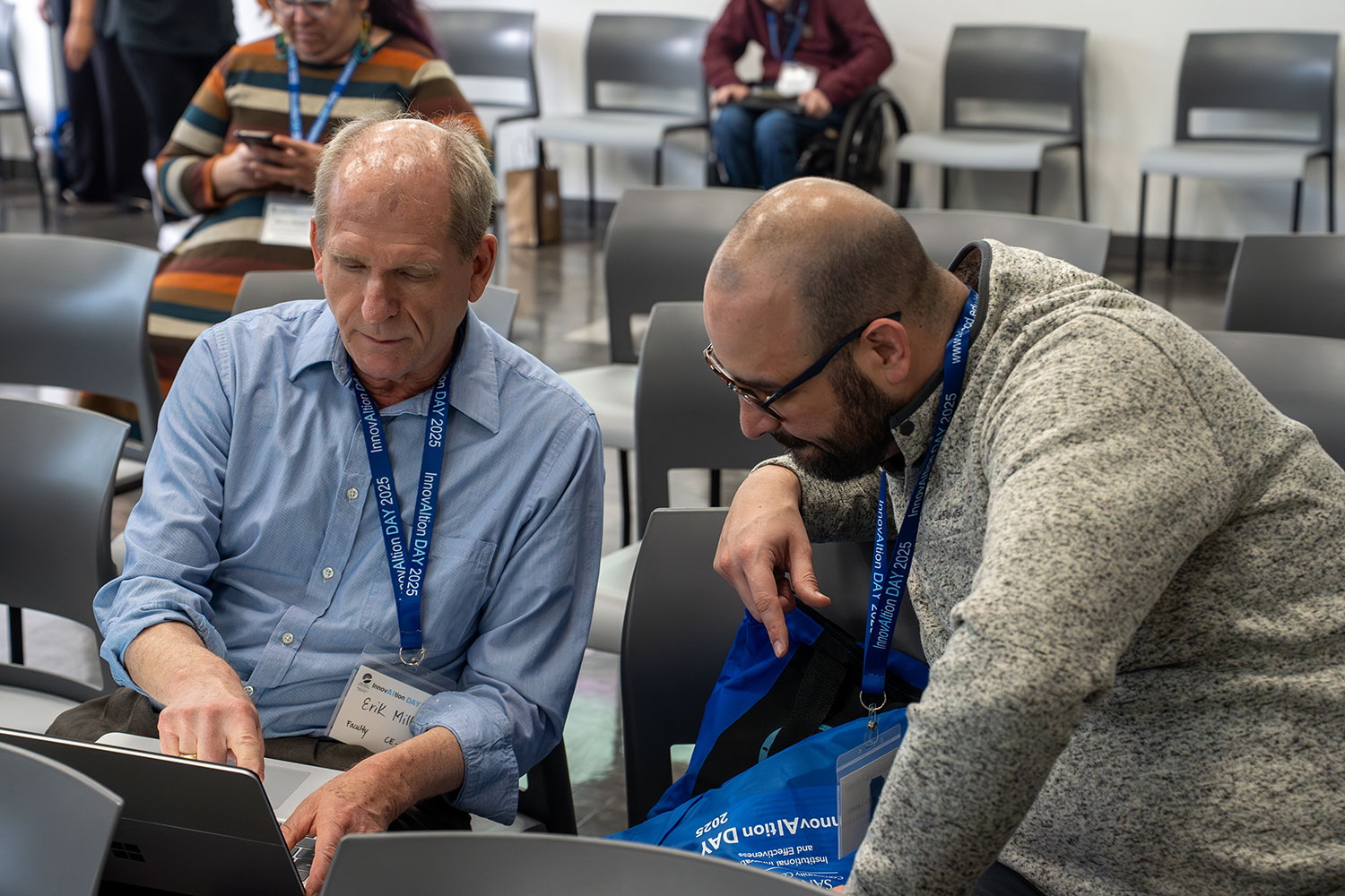 
Two audience members looking at a laptop.
