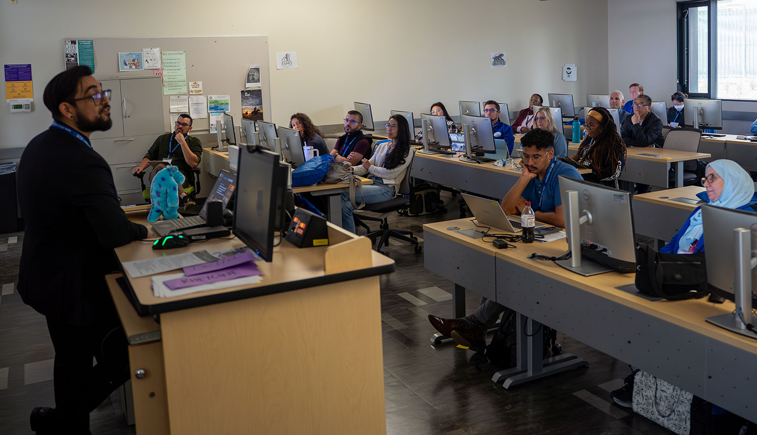 
A speaker addresses a classroom full of people
