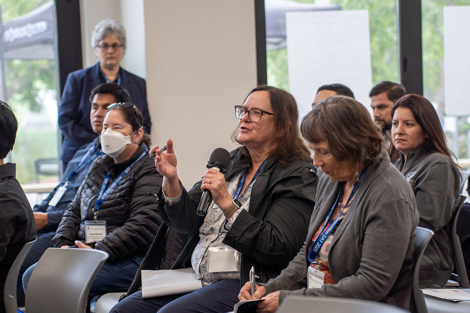 
A woman in the audience asking the panel a question.
