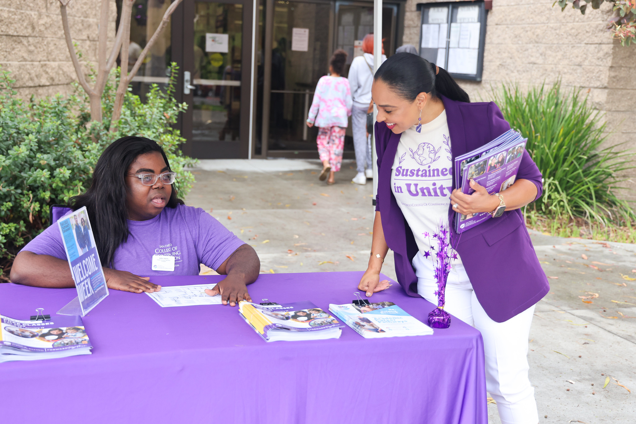 
President Tina King stops by a Welcome table at the entrance of the Educational Cultural Complex.
