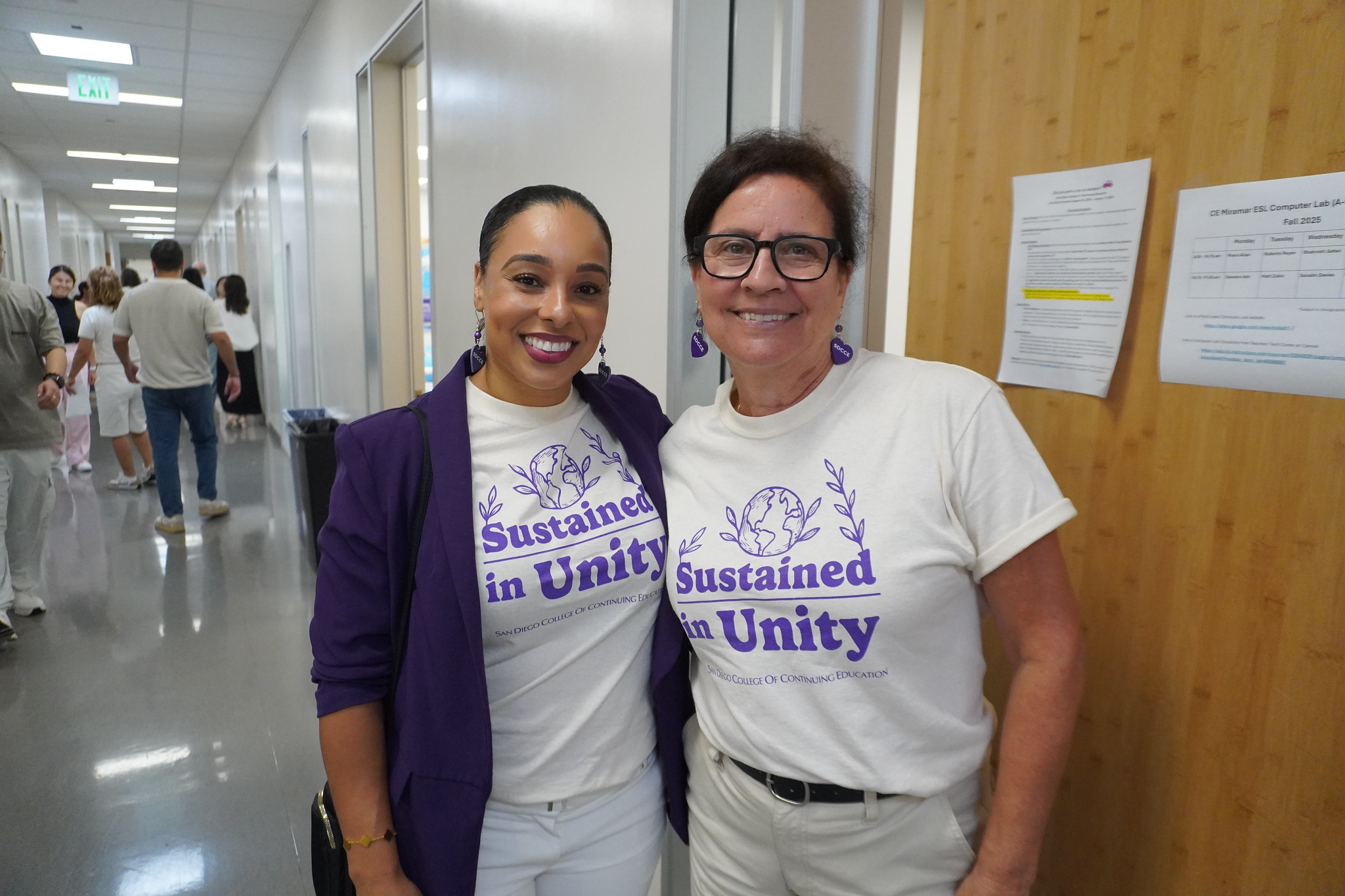
President Tina King with an employee. Both are wearing white t-shirts that say Sustained in Unity.
