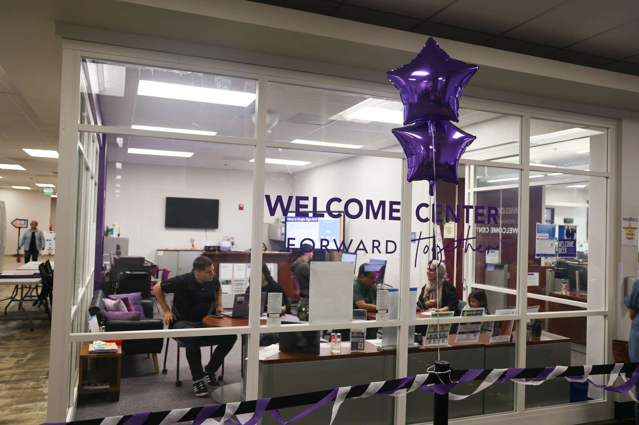 
The entrance of the welcome center with two purple star mylar balloons.
