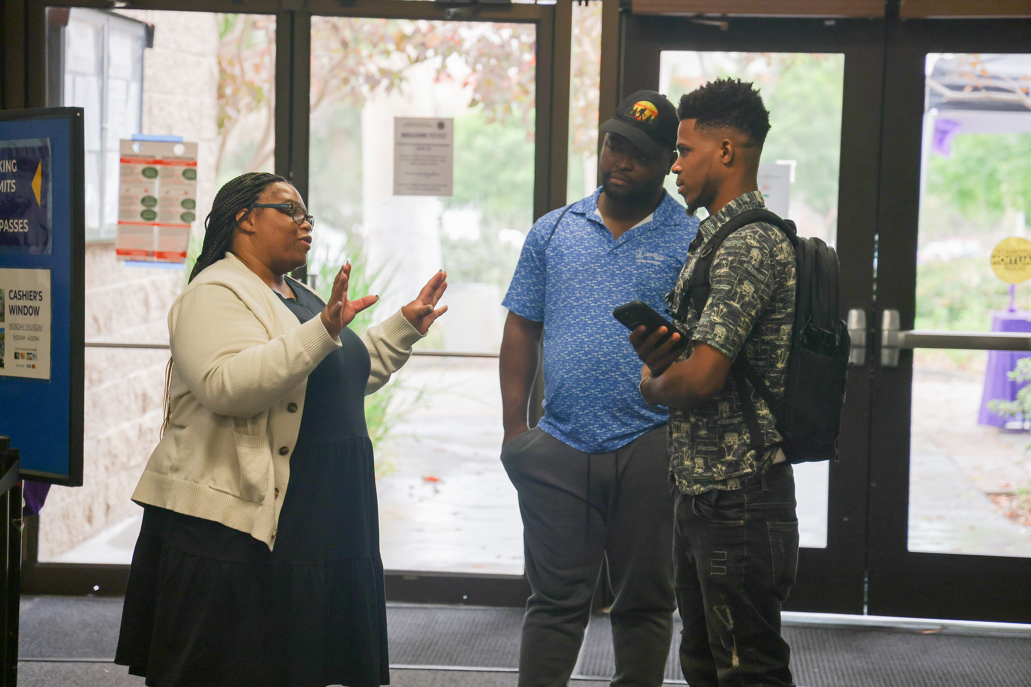 
Two students stop to talk to a woman in the lobby on campus.
