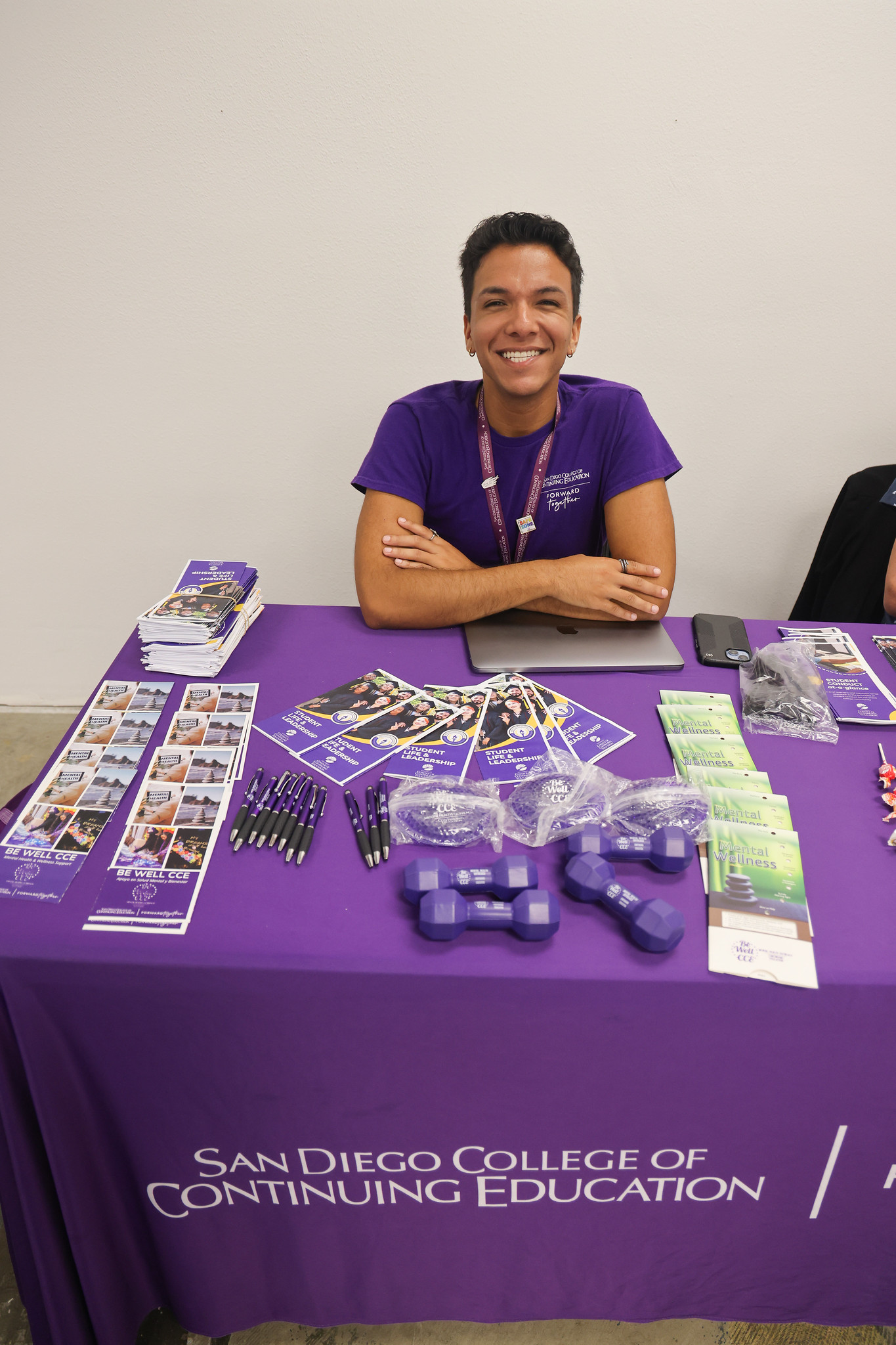 
A worker at a welcome table with information pamphlets
