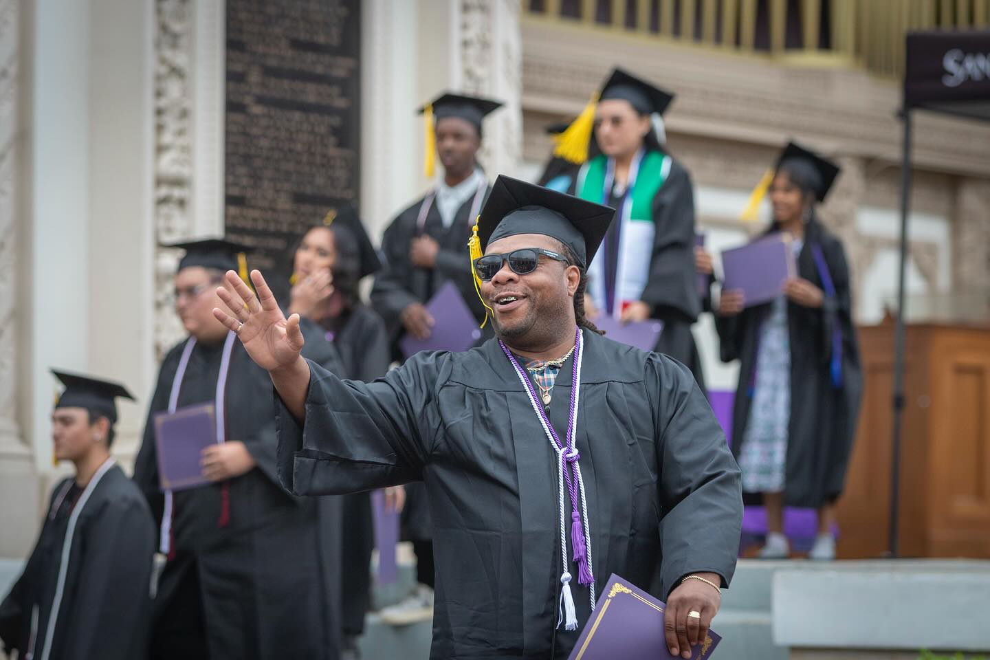 
A graduate waves to the crowd after receiving his diploma.
