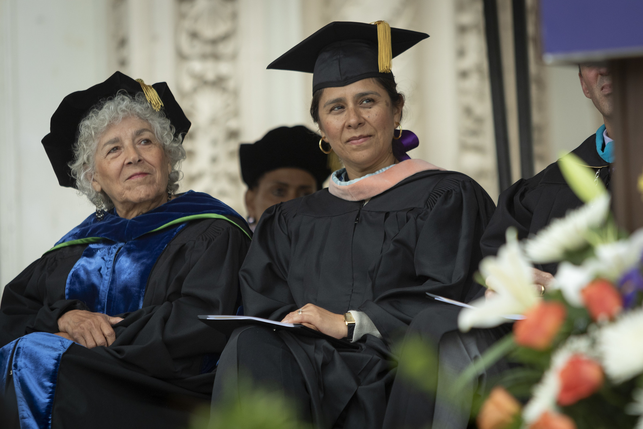
Trustees Maria Nieto Senour and Geysil Arroyon seated on stage during commencement.
