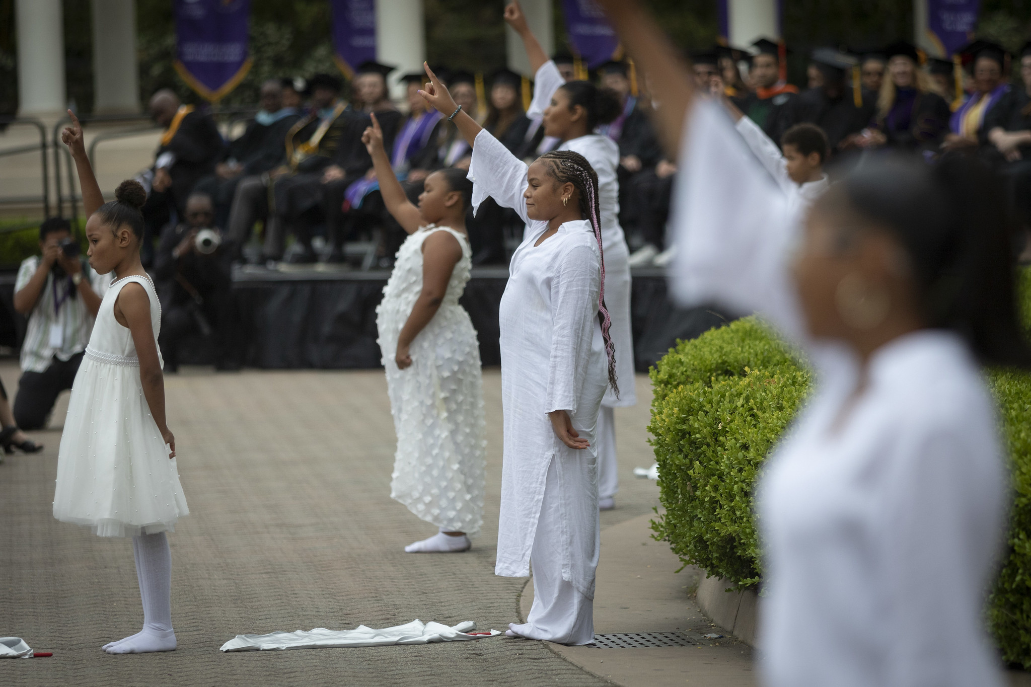 
Five children dressed in all white perform a dance at commencement.
