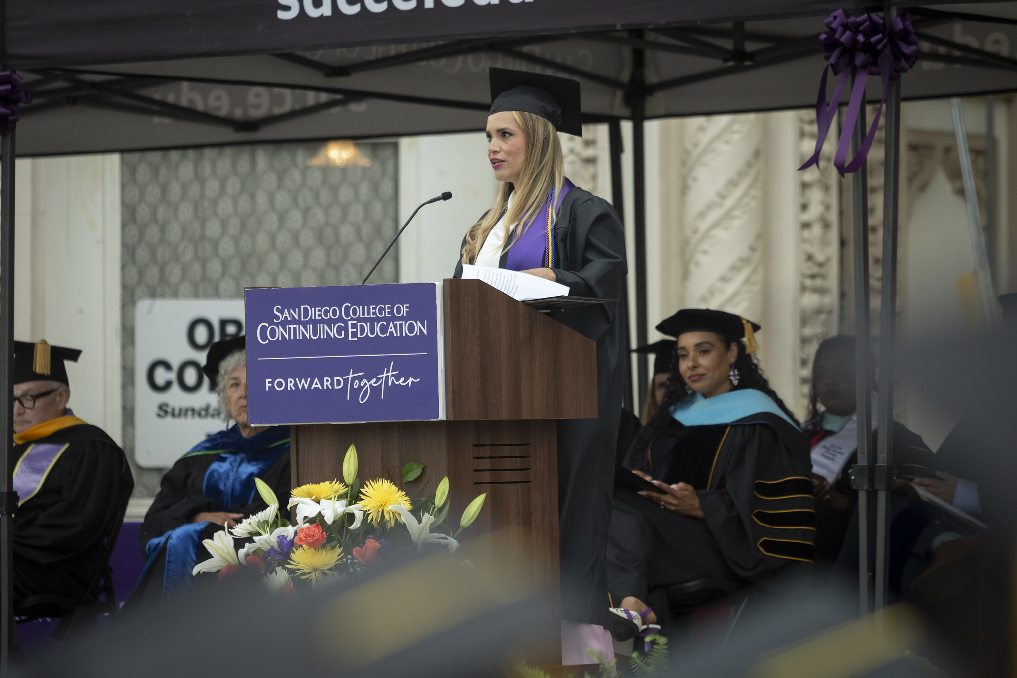 
College of Continuing Education Associated Student President Haydee Zuniga speaking at a podium.
