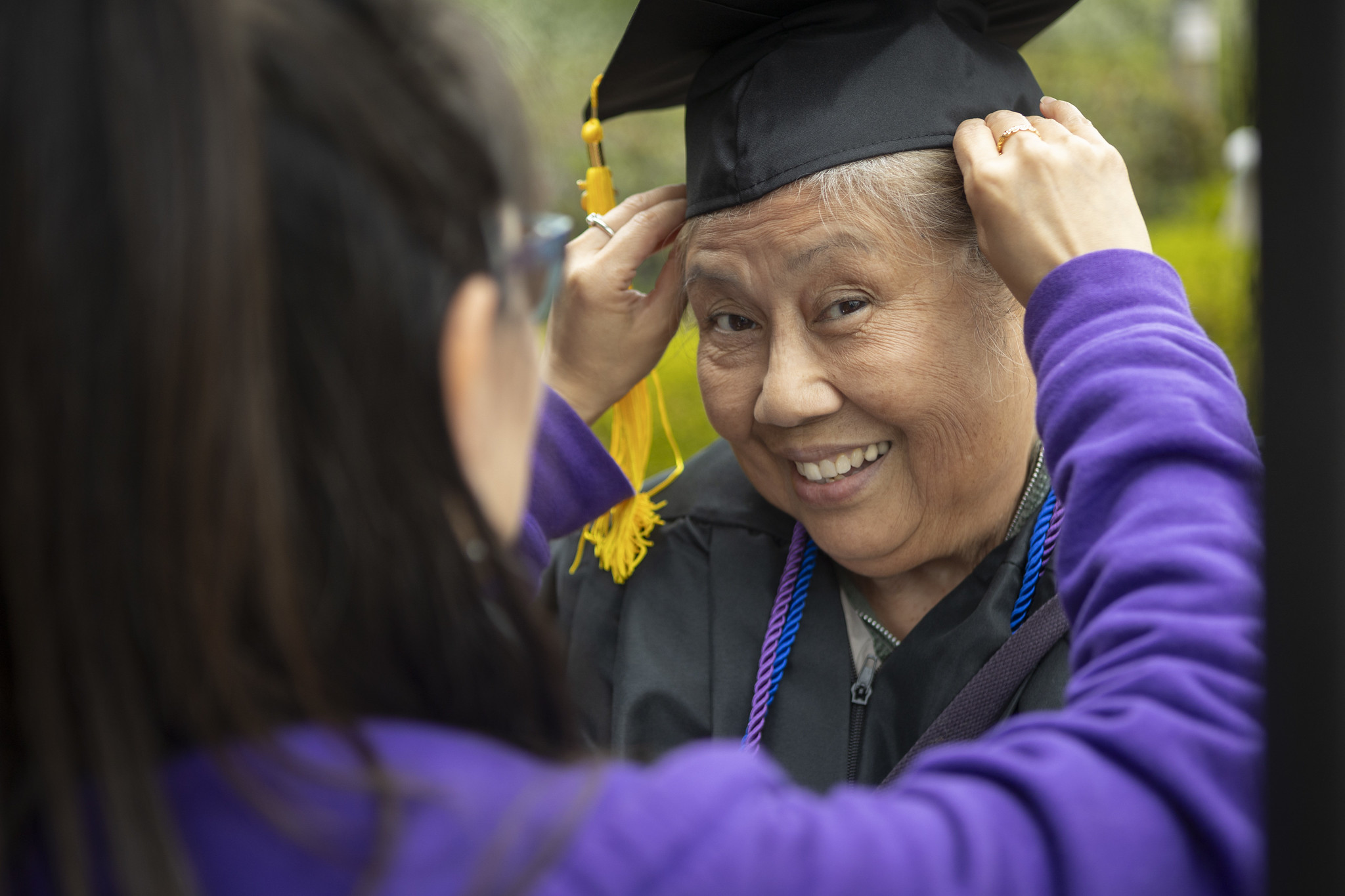 
A graduate gets some help putting on her cap.
