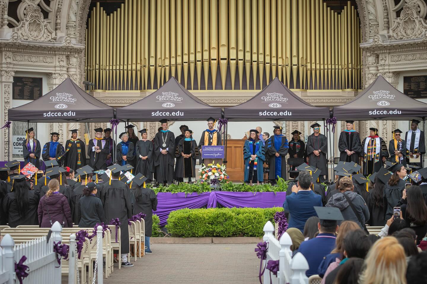 
Faculty, staff, college and district leaders lined up in graduation regalia on stage at the beginning of commencement.
