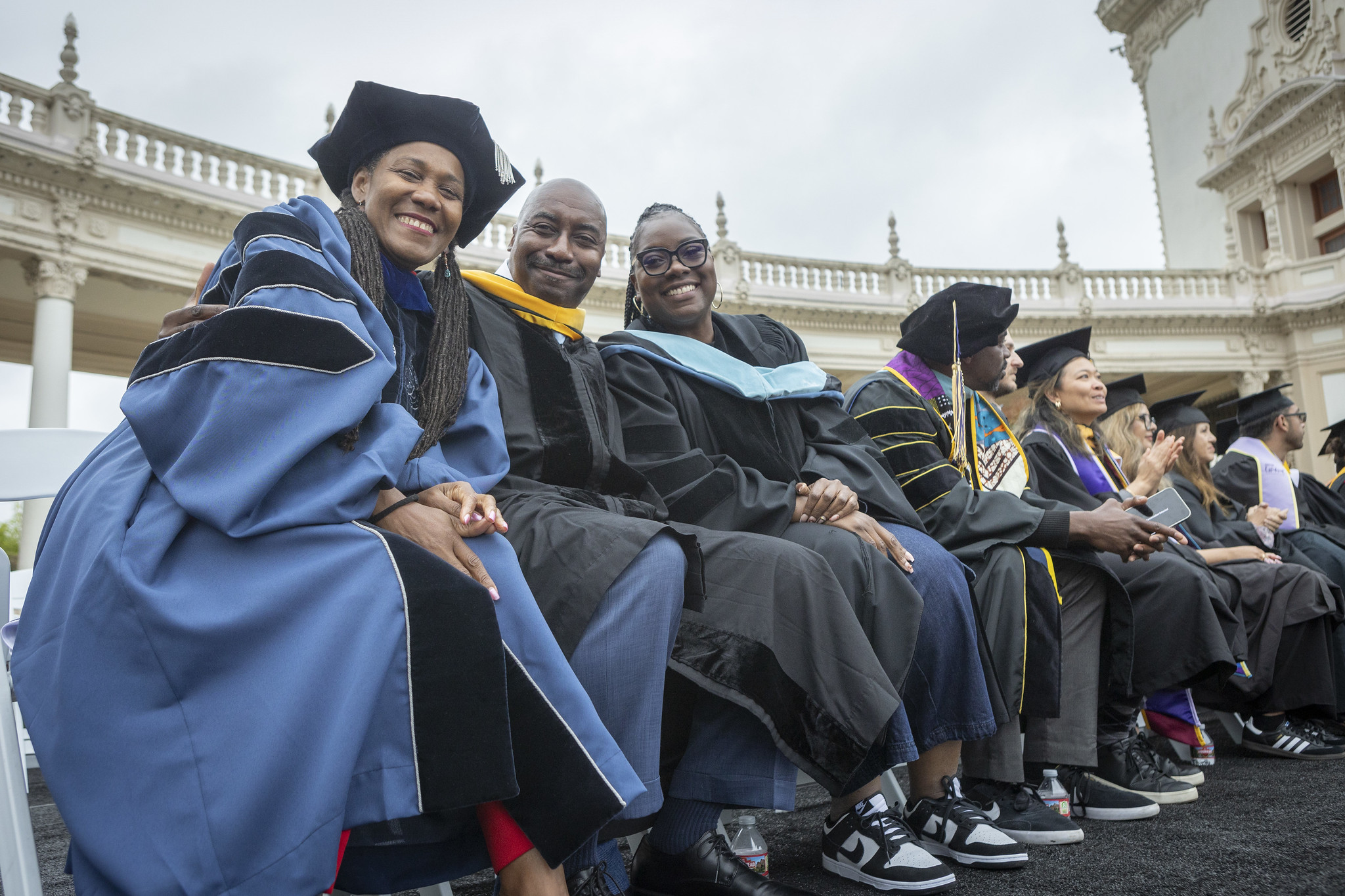 
Faculty and staff on stage in graduation regalia.
