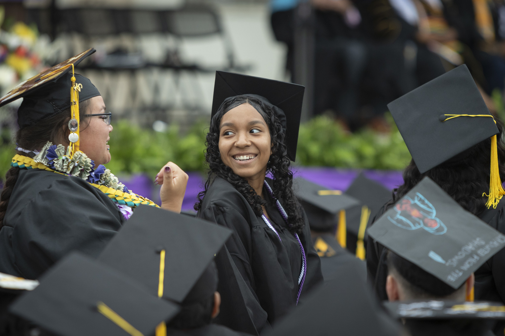 
A smiling graduate seated in the crowd.
