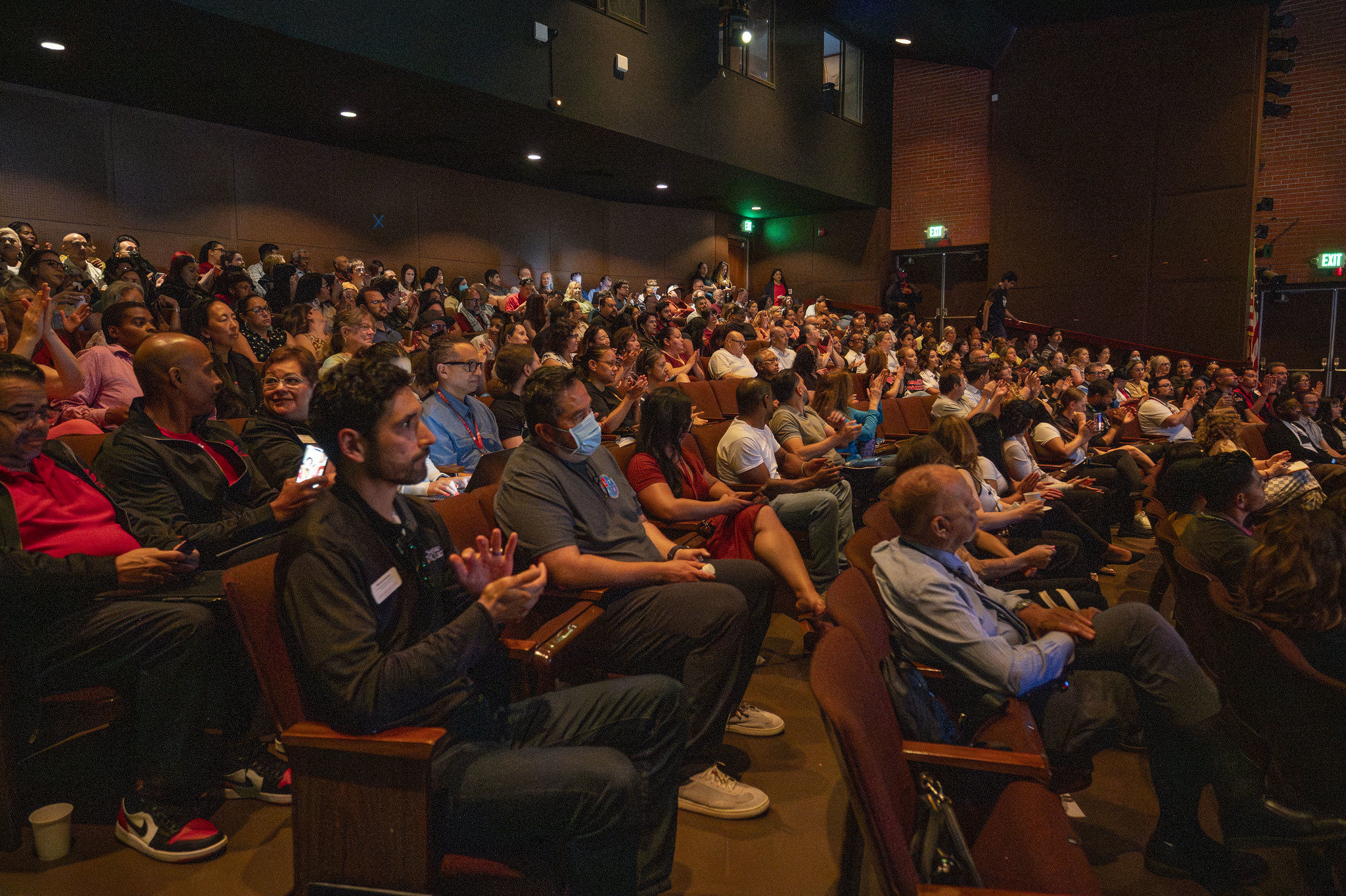 
The audience in a theater listening to the presentation.
