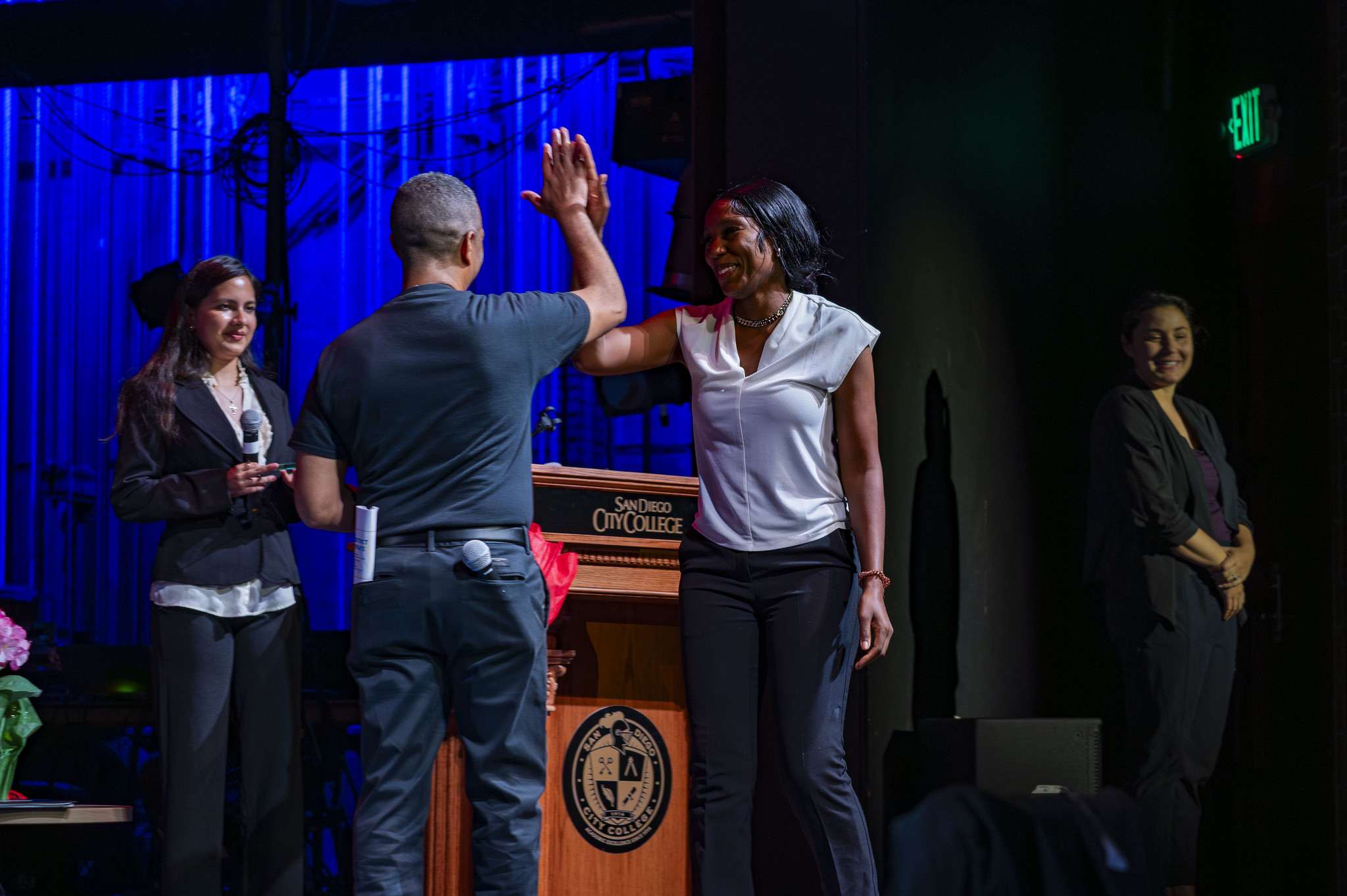 
Two people high-five on stage.
