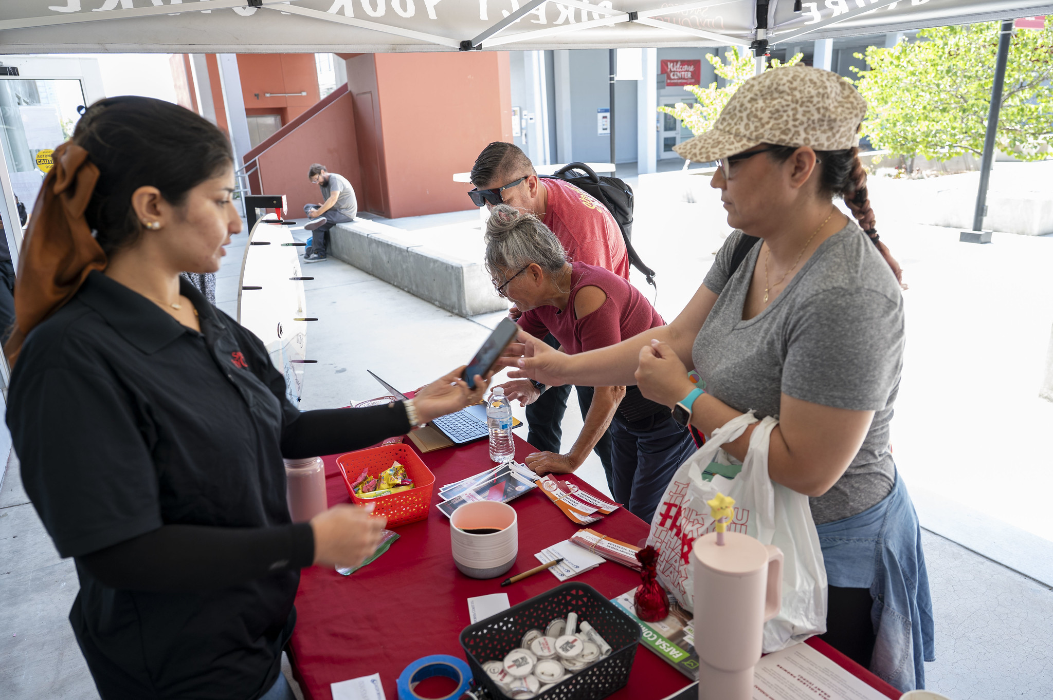 
Three people stop at a welcome table.
