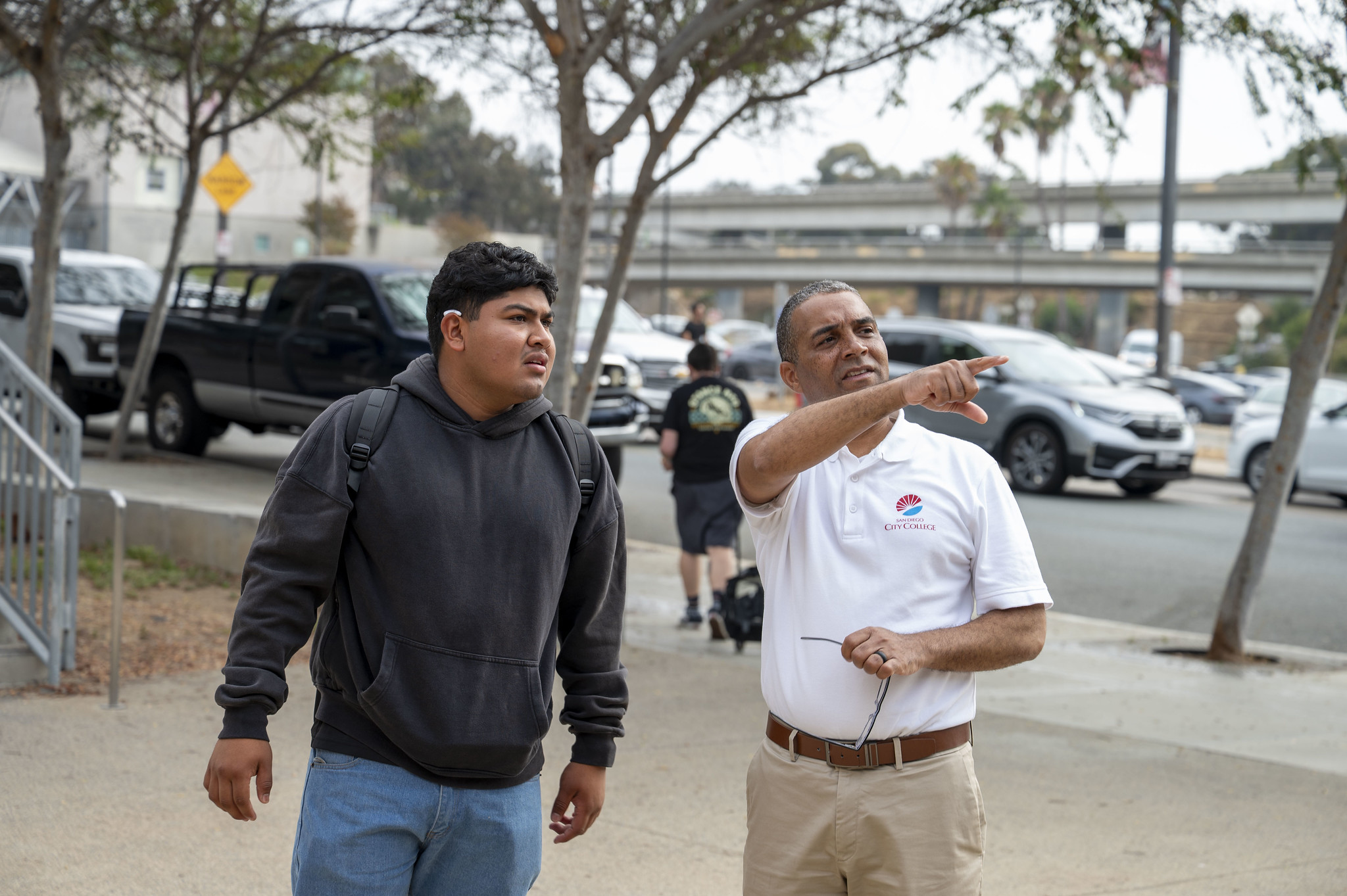 
City College President Ricky Shabazz points a student in the right direction on campus.
