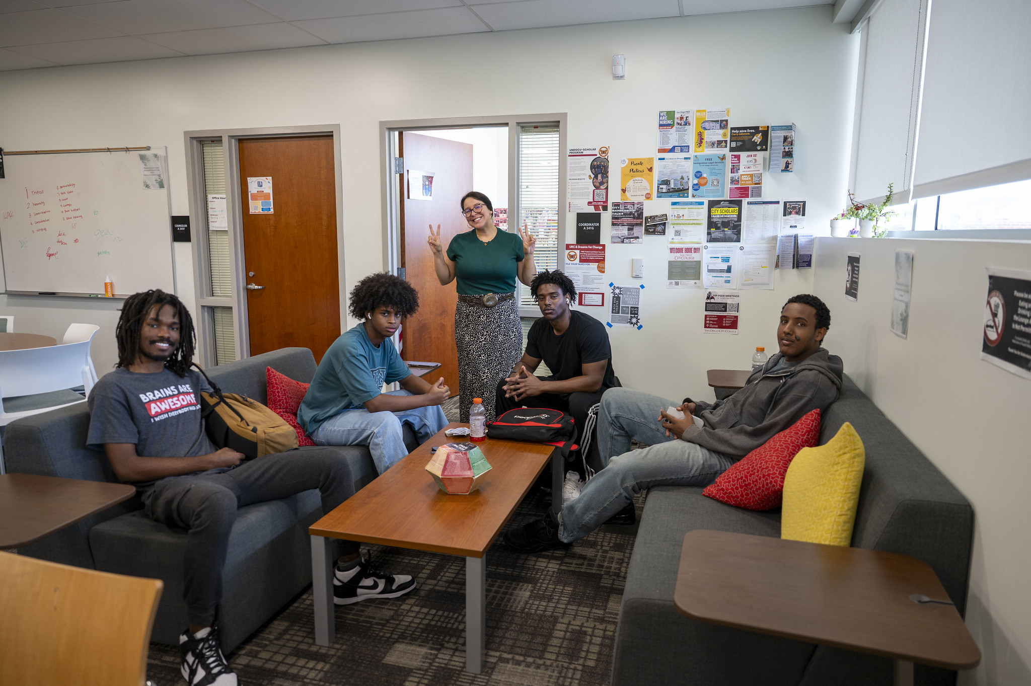 
Four students and a staff member in a lounge area.&nbsp;
