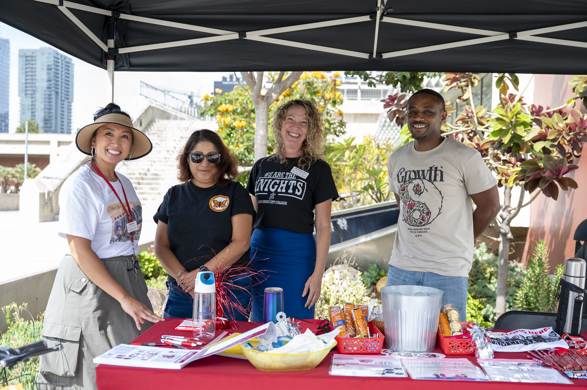 
Four people working at a City College Welcome tent.
